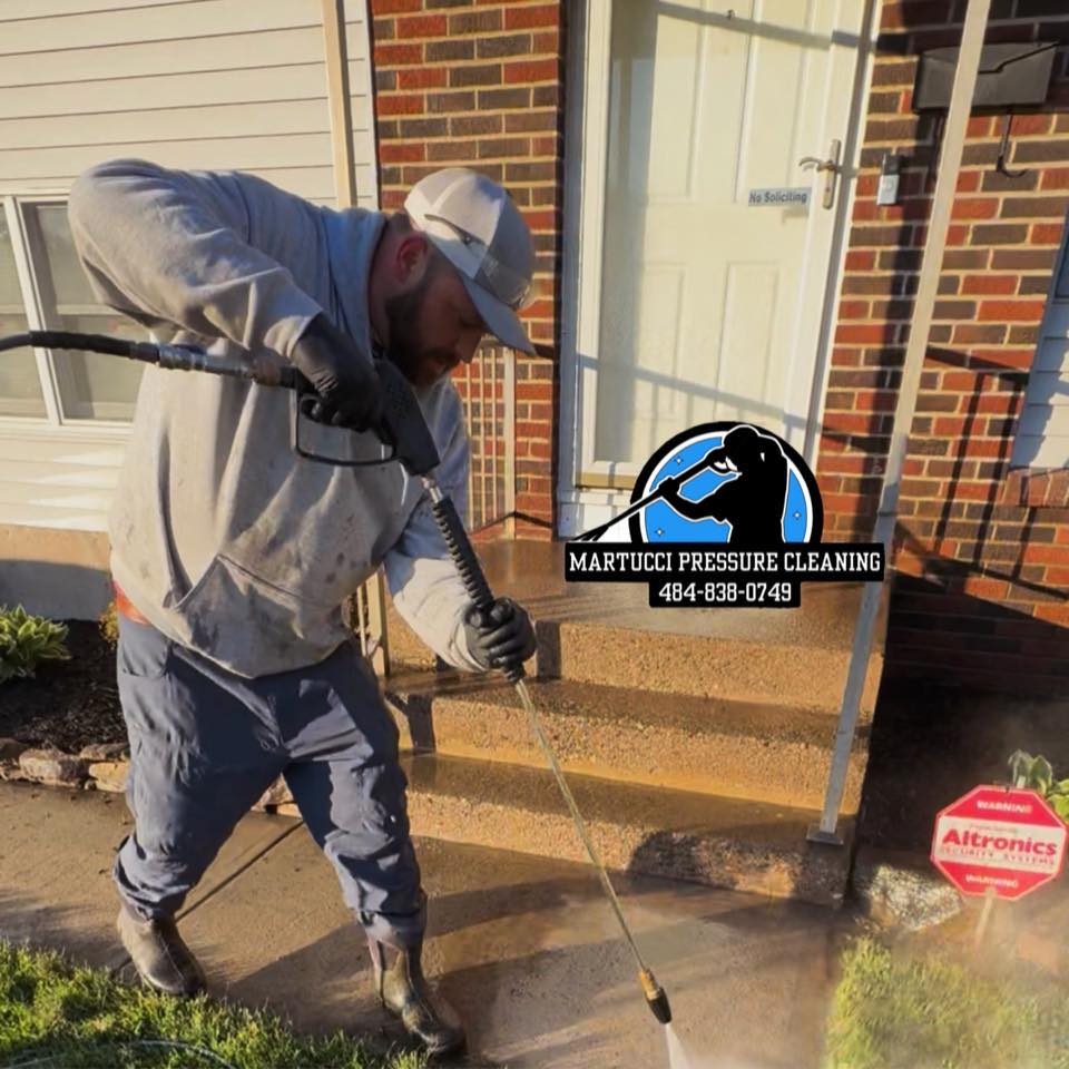 Sam Martucci pressure washing a concrete walkway in the Lehigh Valley